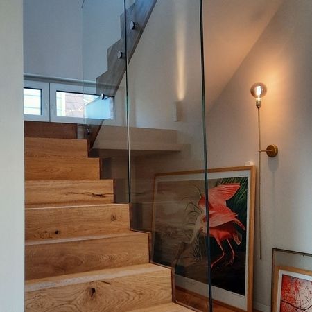 Eine Holztreppe mit Glasabsturzsicherung