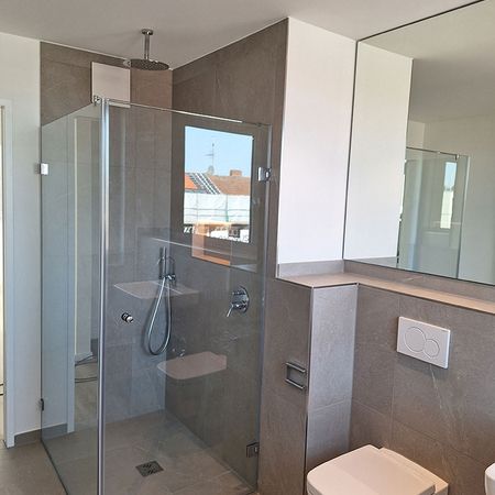 Eine Eckdusche mit bewegbaren Türen aus Glas