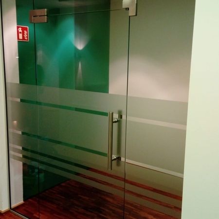 Eine Ganzglastür mit Milchglaselementen als Sichtschutz