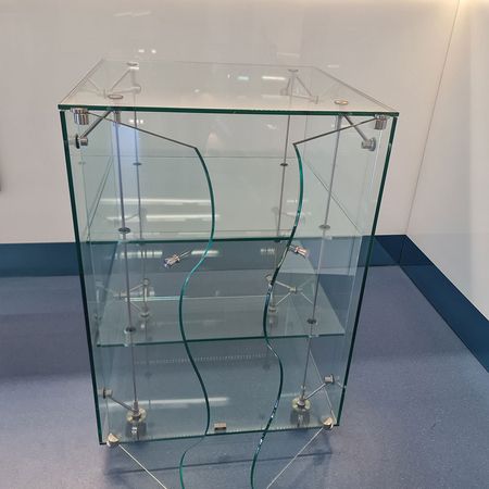 Eine Vitrine aus Glas mit geschwungenen Türen