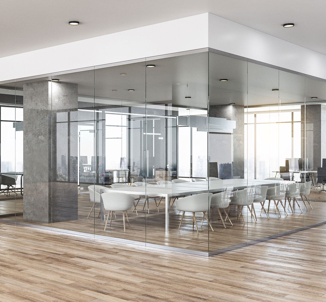 Ein Raum mit Glaswänden und einem großen Tisch in der Mitte